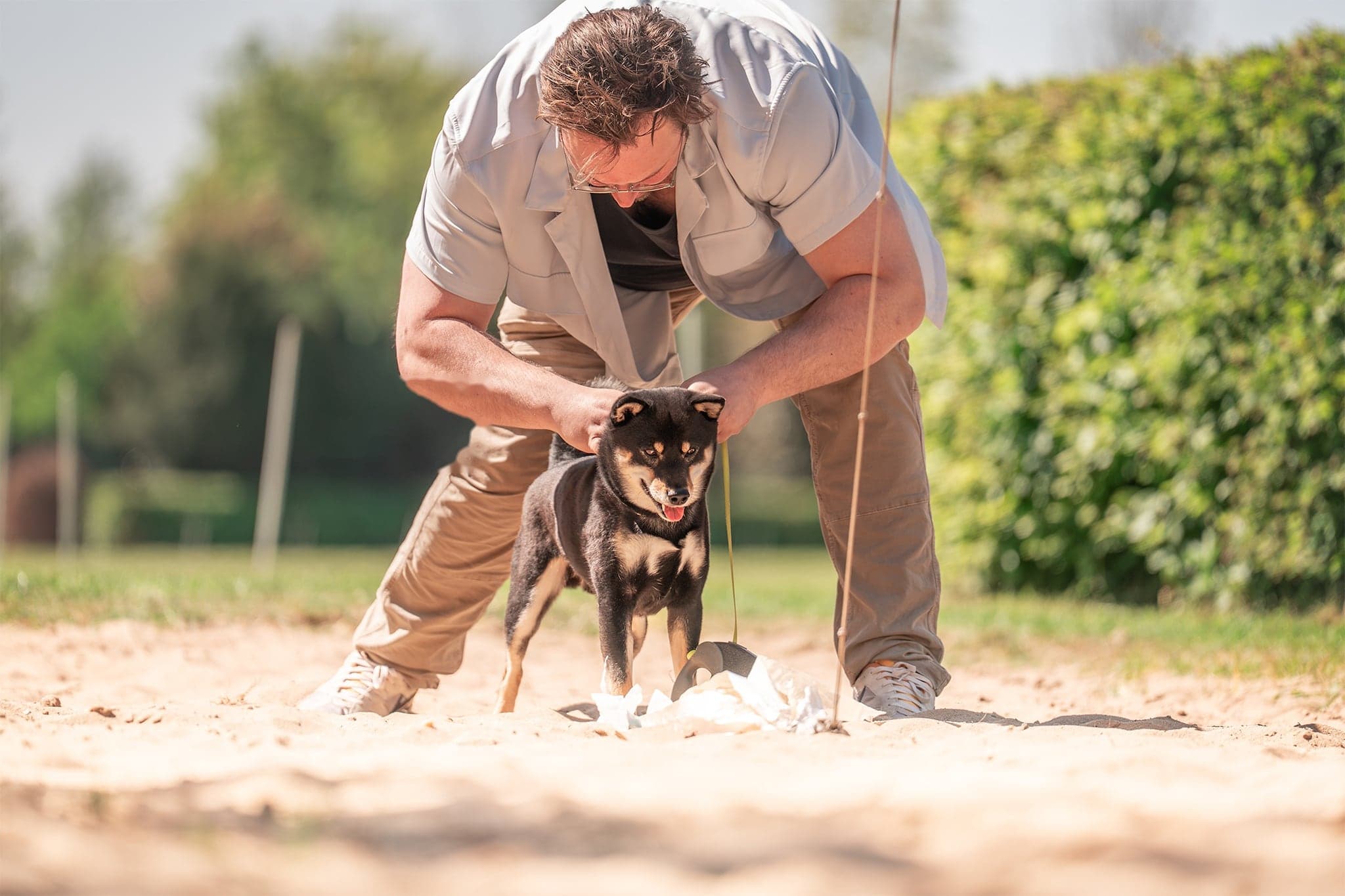 Luuk met een jonge Shiba Inu op het zand